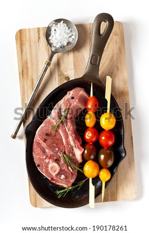 Lamb chops with cherry tomato and rosemary herb ready to cook. Selective focus.