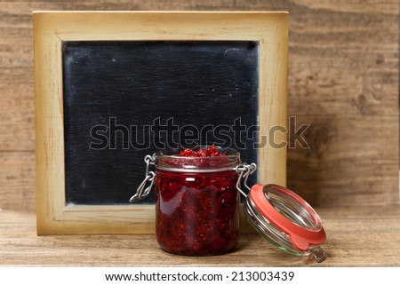 Raspberries jam with chalkboard. Selective focus.
