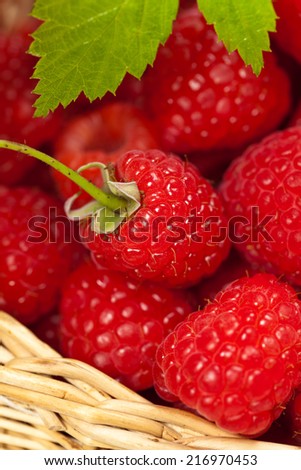 Ripe raspberry with green leaf extreme close up. Selective focus. Shallow depth of field.