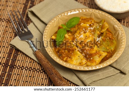 Cheese and spinach stuffed ravioli pasta with tomato sauce and parmesan cheese. Selective focus.