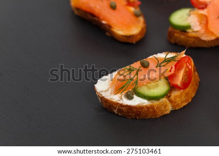 Finger food canapes with smoked salmon and cream cheese. Selective focus.