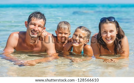 Happy family playing together in the transparent sea