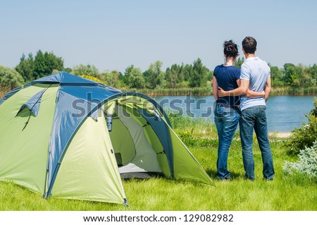 Holiday camping - Man And Woman Couple Camping near A Tent In The Countryside