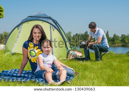 Families resting on the grass and camping with tent