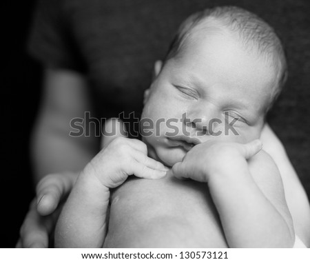 Newborn baby sleep in A Father hands. Black-and-white photo