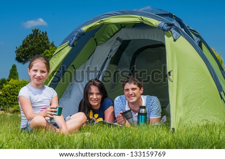 Families resting on the grass and camping with tent