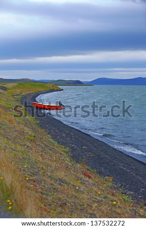 Iceland landscape with red boat on Myvatn lake in northern Iceland. Vertical view