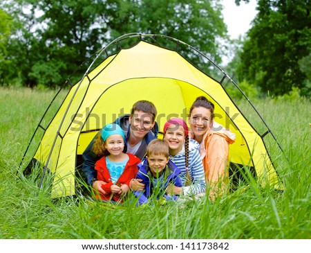 Family with three kids in tent in camping on the nature.