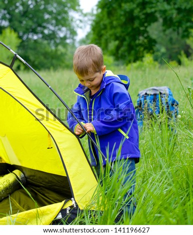 Cute little boy camping with tent outdoor.
