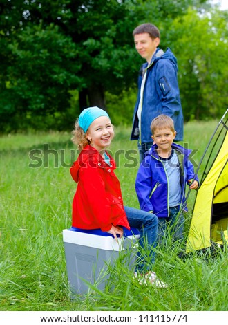 Summer, family camping - lovely sister and brother with father near camp tent. Vertical view