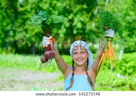 Vegetable garden - little gardener with bunch of organic carrots and beets