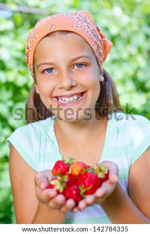 Young girl holding in hand organic natural healthy food produce - strawberries. Vertical view