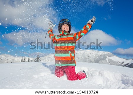 Skiing, winter, teenage girl - young skier girl playing in snow in winter resort