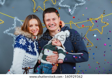 Christmas theme - Portrait of happy family with baby in winter clothing in studio