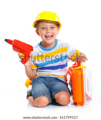 Little builder. Boy in a helmet plays in the builder with tools. Isolated over white.