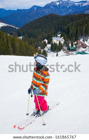 Girl on skis in soft snow in the mountains