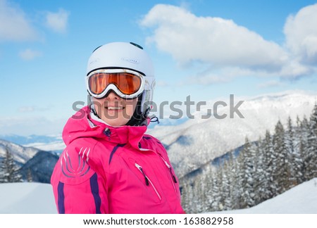 Portrait of young woman on skis in soft snow in the mountains