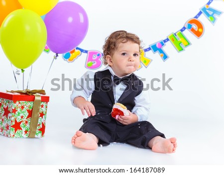 Babies\' first birthday one year old with colorful balloons. Isolated over white.