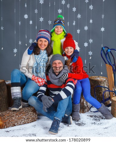 Winter Fashion. Happy family in winter hat gloves and sweater in studio.