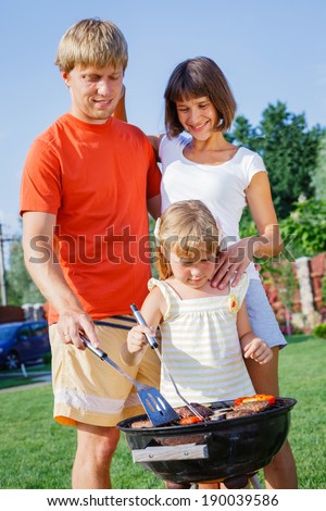 Happy family on vacation having barbecue outdoors