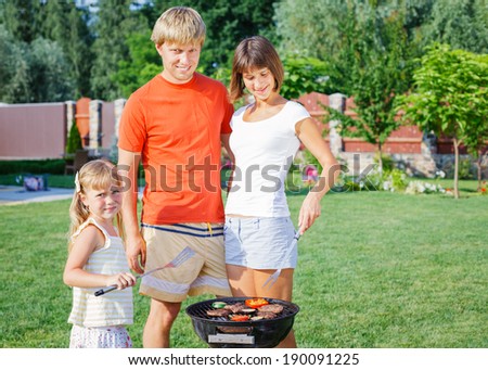 Happy family on vacation having barbecue outdoors