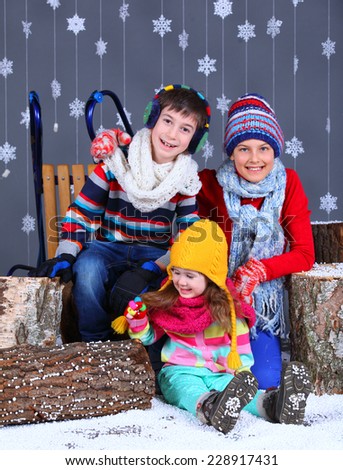 Winter Fashion. Adorable happy boy and girls in winter hat, gloves and sweater in studio.