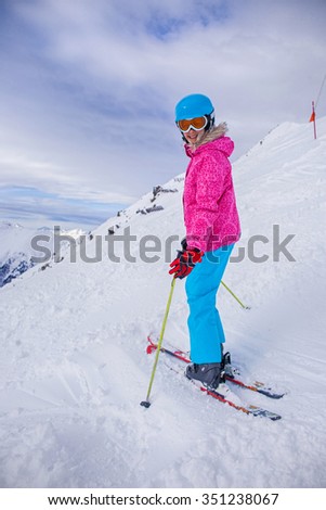 Skiing, winter, child - portrait of young skier girl in helmet and goggles in winter resort