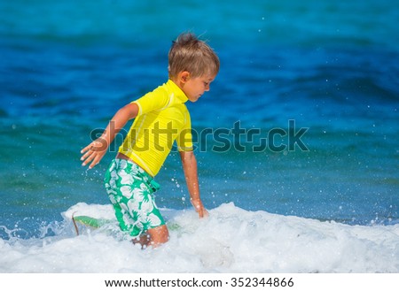 Little cute boy with learning surfing in the sea