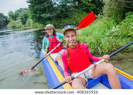 Active happy family. Girl with her mother having fun together enjoying adventurous experience kayaking on the river on a sunny day during summer vacation