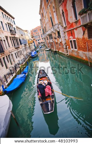 Gondolier navigate gondola on the canal in Venice