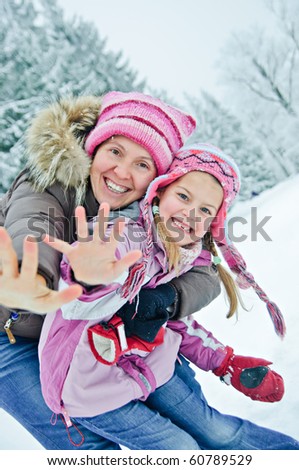 Mother and daughter having fun in the winter park