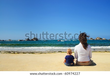 Mother and son looking at the waves on the beach of the Atlantic, France