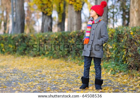 Little Miss. Pretty cute girl walks in autumn park