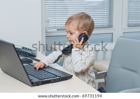 Small cute business boy with phone and computer in office