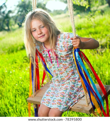 stock-photo-young-cute-girl-on-swing-with-ribbons-in-the-garden-78395800.jpg