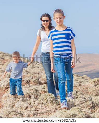 Family of three - mother and her child hiking in the cross-country