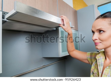beautiful young woman open the kitchen hood at home