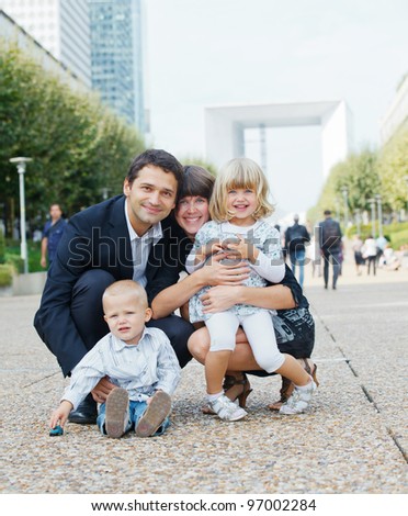 Happy family of four walking to la Defense, Paris. Vertical view