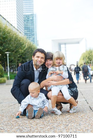 Happy family of four walking to la Defense, Paris. Vertical view