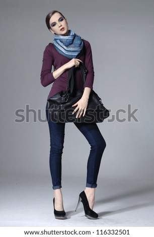 full length shot of fashion model in scarf posing on grey background