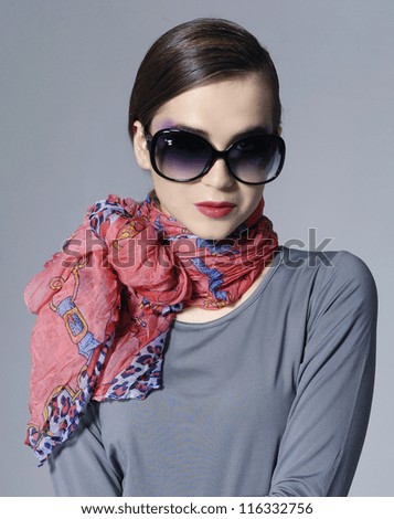 Fashion stylish girl in scarf on gray background