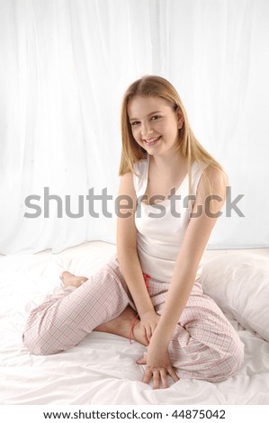Portrait of young beautiful happy woman on bed