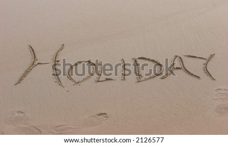 Holiday written on the beach, tempting you to go on a vacation