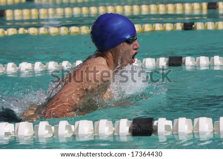 Breaststroke swimming style by male swimmer with blue cap