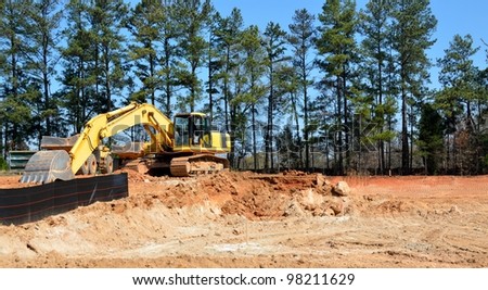 Excavator at constrution site rural Georgia showing Georgia\'s red clay dirt.