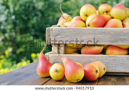 Ripe juicy pear in a container on a wooden table.