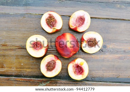 Peaches and peach slices on a wooden table