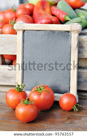 Products on the market. Tomatoes and a price tag in a wooden frame. Price list for food.