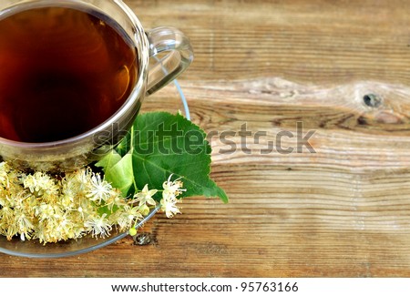 Tilia. Linden tea. Tea on a wooden table in a glass bowl. Tea with linden flowers.