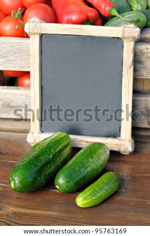 Products on the market. Cucumbers and a price tag in a wooden frame. Price list for food.